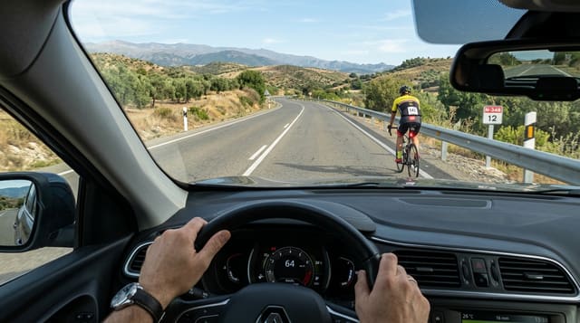 Ilustración del examen DGT: En una vía interurbana, cuando un turismo adelanta a una bicicleta, ¿está permitido...
